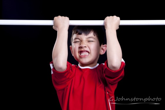 Boy doing a pull-up.