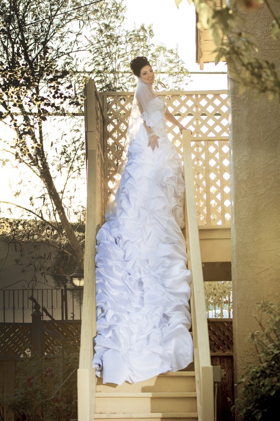 A beautiful bride and her long dress shine in the light