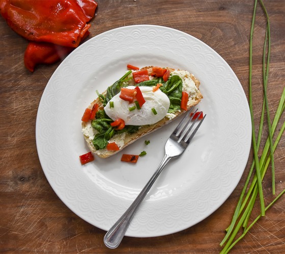 Flatlay shot of poached egg and country toast with greens.