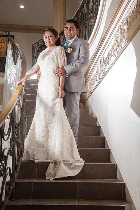 Wedding Couple take their picture on mansion stairway.