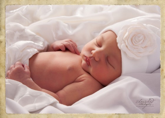 Newborn Baby in White Flower Hat Studio